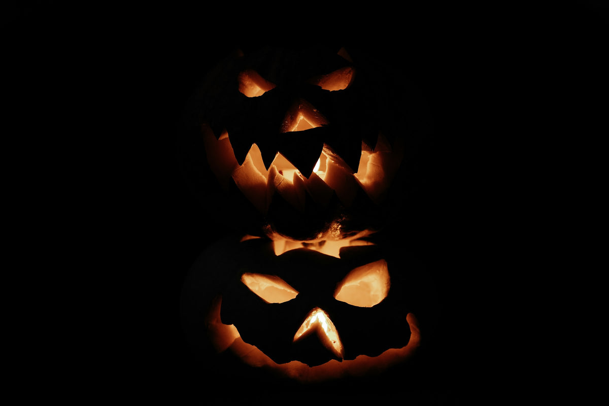 Glowing jack-o'-lantern pumpkins on a dark Halloween night